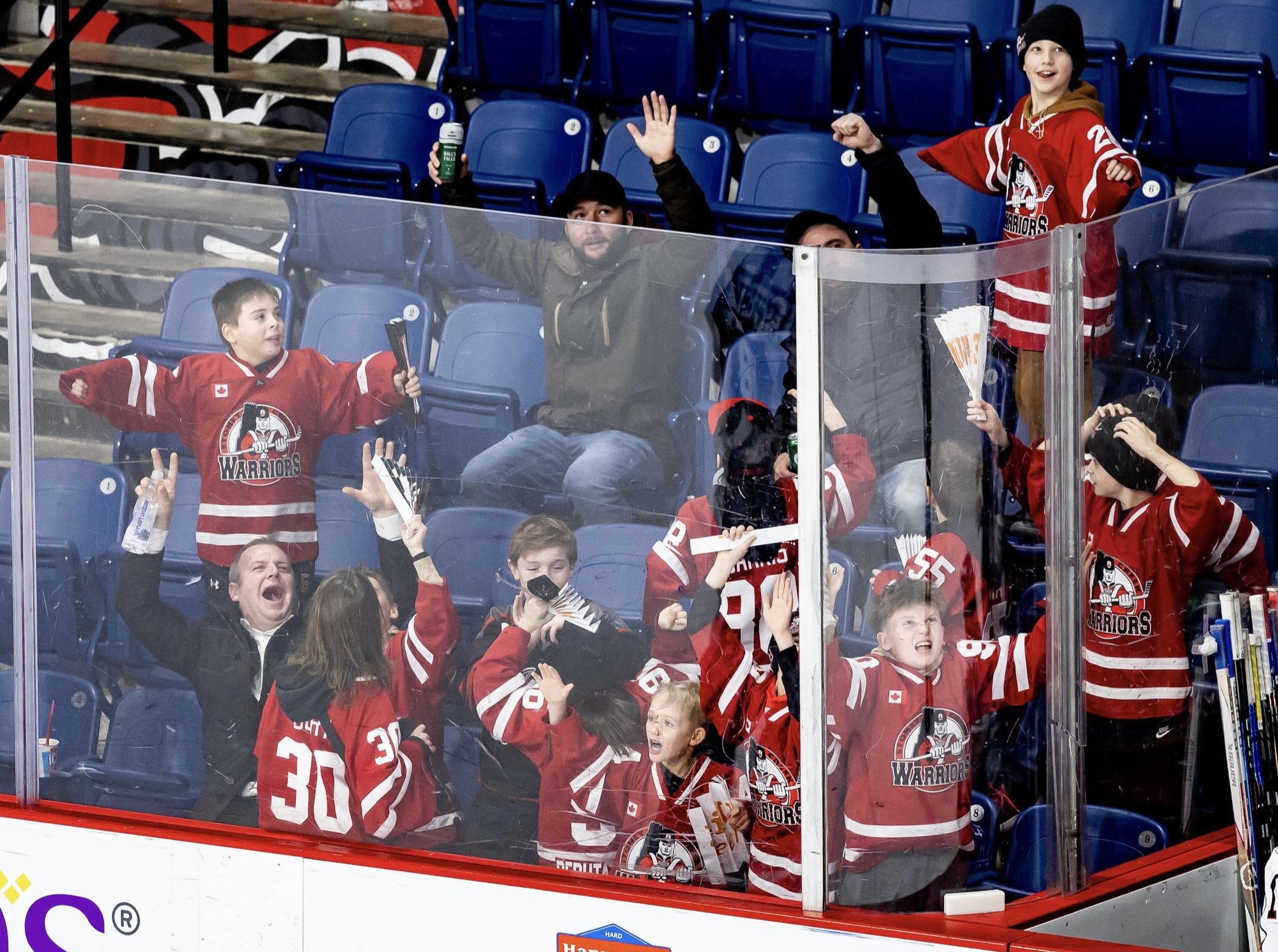 Grroup of children and adults celebarting rinkside at Niagara Icedogs game Grroup of children and adults celebarting rinkside at Niagara Icedogs game